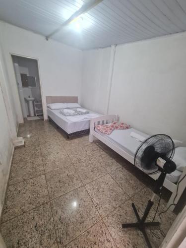 a room with two beds and a fan in it at Casa de Maria in Aparecida
