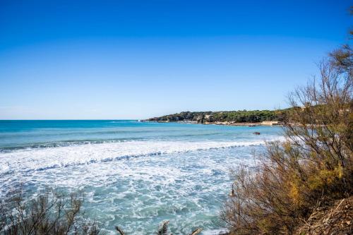 a view of a beach with waves in the water at Villa Casa Marina in Castiglioncello
