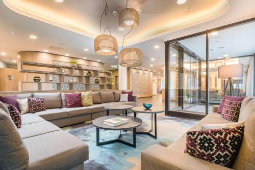 a large living room with couches and tables at Best Western Hotel Airport Frankfurt in Frankfurt/Main