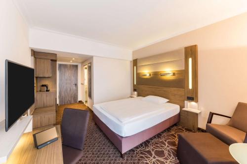 a hotel room with a bed and a couch at Best Western Plus Hotel Koeln City in Cologne