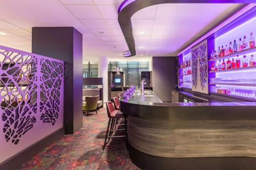 a bar in a hotel room with purple lighting at Best Western Plus Hotel Koeln City in Cologne