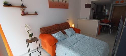 a bedroom with a bed with an orange blanket at Apartamento Elegance Benidorm in Villajoyosa