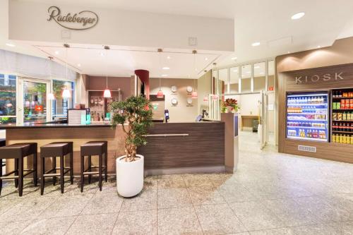 a restaurant with a bar with stools and a counter at Best Western Plus Hotel Dresden City in Dresden