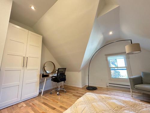an attic room with a bed and a desk at Lovely 1- bedroom Unit in Grimsby in Grimsby