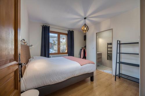 a bedroom with a bed and a window and a mirror at Appartement BOZEN - 100M2- 6 personnes - Bozel - Vallée de Courchevel in Bozel