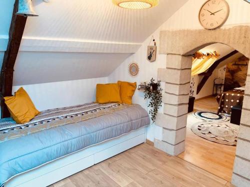 Cette chambre dispose d'un lit avec une horloge murale. dans l'établissement COCON Le Panoramique 10min Honfleur Port Plage Parking gratuit, à Honfleur