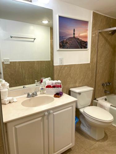a bathroom with a sink and a toilet and a mirror at Family Stay Ocean Reserve Resort Sunny Isles in Sunny Isles Beach