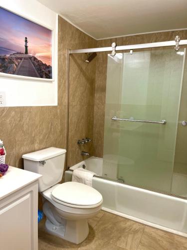 a bathroom with a toilet and a glass shower at Family Stay Ocean Reserve Resort Sunny Isles in Sunny Isles Beach