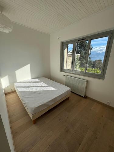 une chambre blanche avec un lit et une fenêtre dans l'établissement Séjour cosy à Saint Nazaire, à Les Eymes