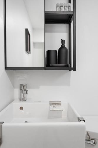 a bathroom sink with a black container on a shelf at Luxury Old Montreal Parking with Yard Patio 10 Guests in Montréal
