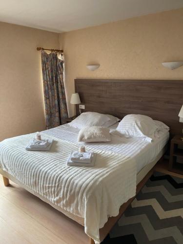 a bedroom with a large bed with two trays on it at Hôtel du Commerce in Semur-en-Auxois