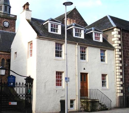 a large white building with a clock tower at Jacobite's Retreat, 17th century cottage in the heart of Inverness in Inverness