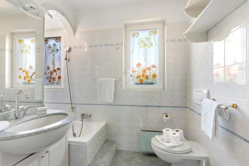 a bathroom with a sink and a tub and a toilet at Villa Anita - Happy Rentals in Caslano