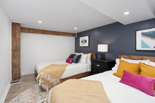 two beds in a room with blue walls at Luxury Old Montreal Parking with Yard Patio 10 Guests in Montréal