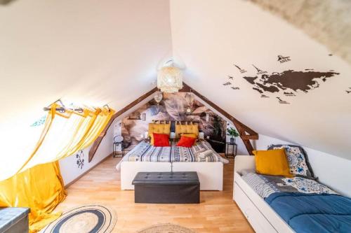 Cette chambre mansardée comprend un lit et un canapé. dans l'établissement COCON Le Panoramique 10min Honfleur Port Plage Parking gratuit, à Honfleur