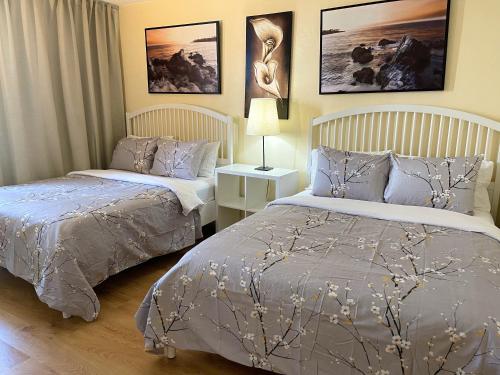 a bedroom with two beds and a table with a lamp at Family Stay Ocean Reserve Resort Sunny Isles in Sunny Isles Beach