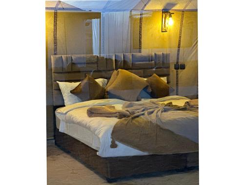 a bedroom with a large bed with pillows at Sahara traveling camp in Merzouga