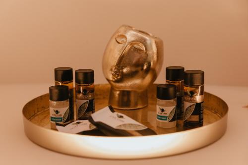 a wooden tray with four bottles of cosmetics on it at Torre di Bassano Luxury Room in Vasto