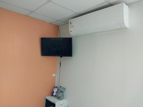 a room with a air conditioner and a tv on a wall at Depart 3 camas in Moyobamba
