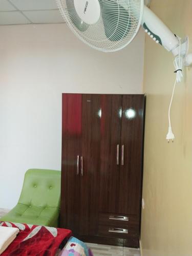 a bedroom with a wooden cabinet and a fan at Depart 3 camas in Moyobamba