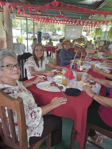 a group of people sitting at a table eating food at Hotel El Cocobolo Food&Rest Room 4 B&B WiFi AC Pkg Free Swimmingpool in Liberia