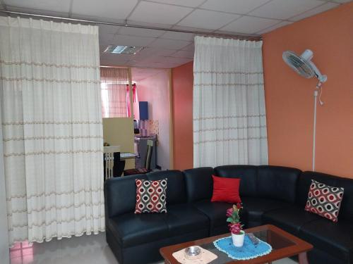 a living room with a black couch and a table at Depart 3 camas in Moyobamba