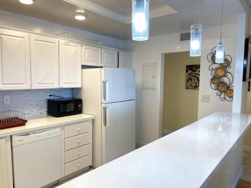 a kitchen with white cabinets and a white refrigerator at Family Stay Ocean Reserve Resort Sunny Isles in Sunny Isles Beach