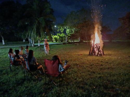 a group of people sitting in chairs around a fire at Hotel El Cocobolo Food&Rest Room 4 B&B WiFi AC Pkg Free Swimmingpool in Liberia