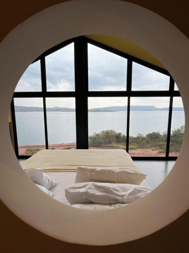 a bed in a room with a large window at Nau Loft Refúgio - Capitolio MG in São José da Barra