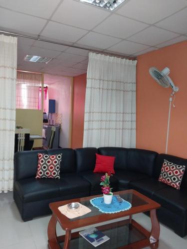 a living room with a black couch and a coffee table at Depart 3 camas in Moyobamba