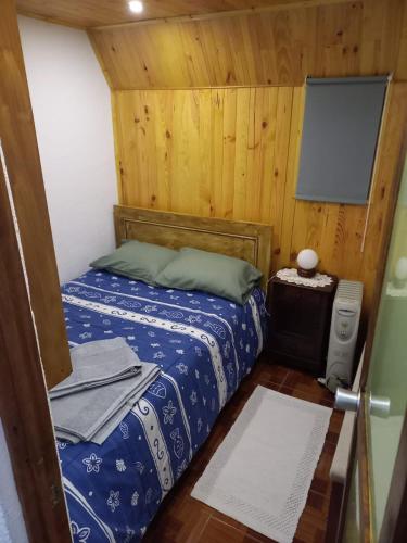 a small bedroom with a bed and a tv at Casa Serrana in Penhas da Saúde