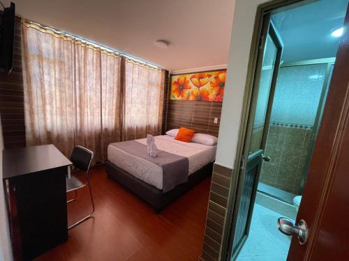 a small bedroom with a bed and a shower at Hotel Ejecutivo 63 In in Bogotá