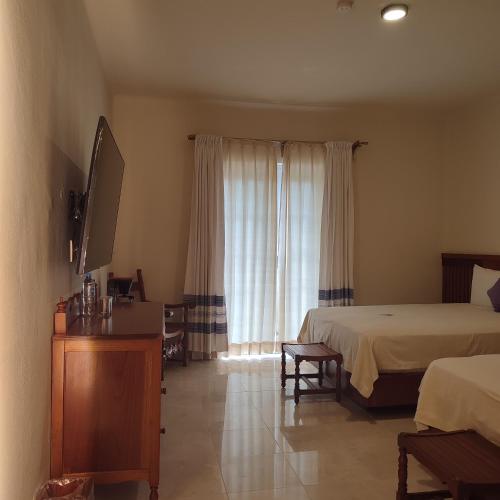 a hotel room with two beds and a window at Hotel Marques Del Valle in Oaxaca City