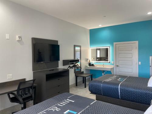 a hotel room with two beds and a flat screen tv at LiV Inn & Suites Houston in Houston