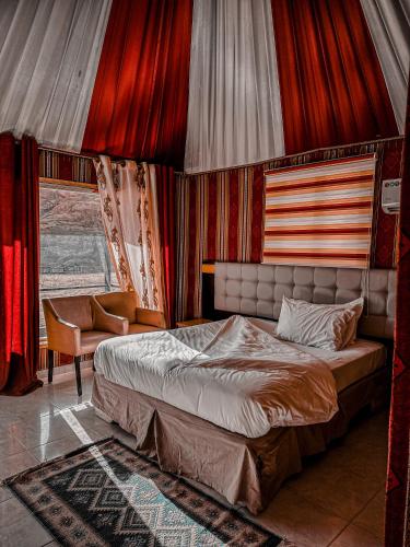 ワディ・ラムにあるRUM YANAL lUXURY CAMPの赤いカーテンが備わるベッドルーム1室です。