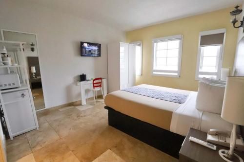 Un dormitorio con una cama y un escritorio. en South of Fifth Family & Pet-Friendly Retreat Across from Best Beach in Miami, en Miami Beach