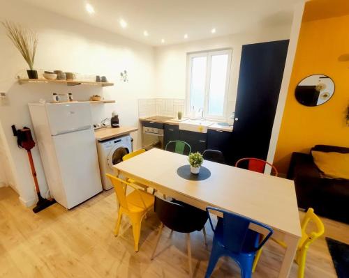 une cuisine avec une table, des chaises et un réfrigérateur dans l'établissement DisneyLand - Paris 20 min - Parking - 8 personnes, à Thorigny-sur-Marne