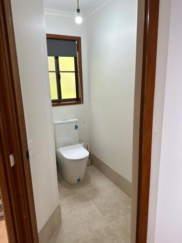 a bathroom with a toilet and a window at Wren Abode 3 Bedroom A-Frame Home Lower Beechmont with Breakfast Basket in Lower Beechmont