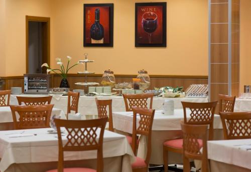 a dining room with white tables and chairs at Hotel Futura Centro Congressi in Naples
