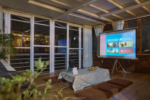 sala de estar con TV de pantalla grande y mesa en Áng Mây Trôi 1, en Khu Chi Lăng