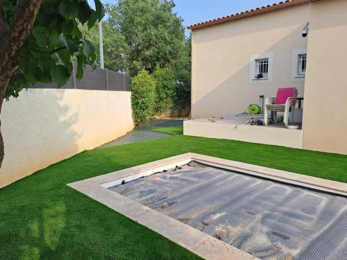 a backyard with a grass yard with a pool at Studio standing in Vergèze