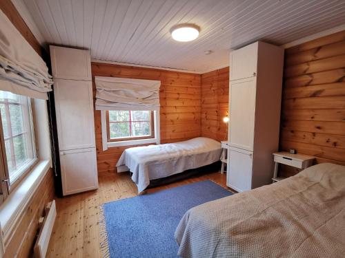 a bedroom with two beds in a wooden cabin at Villa Naukkari in Syöte