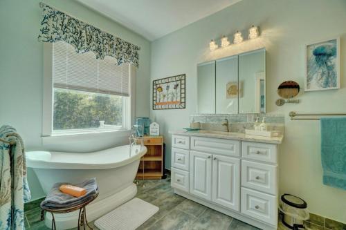 a bathroom with a tub and a sink and a window at Beach Front - Hot Tub - Game Room - 3500SQFT in Cape Charles