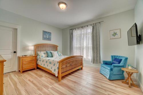 a bedroom with a bed and a blue chair at Beach Front - Hot Tub - Game Room - 3500SQFT in Cape Charles