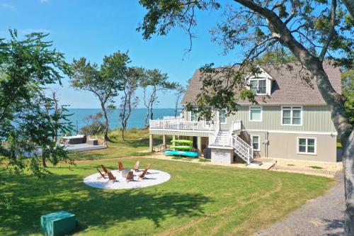 a house with two people laying on the lawn at Beach Front - Hot Tub - Game Room - 3500SQFT in Cape Charles