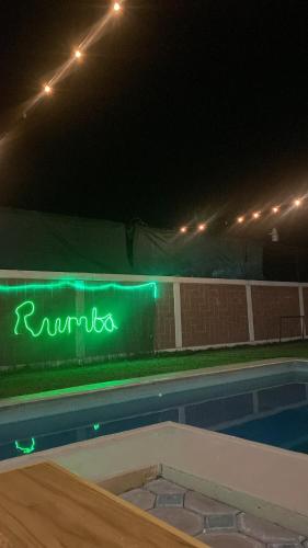a neon sign next to a swimming pool at night at Heated pool, Casa Senda del Son-Cuautla in Los Limones