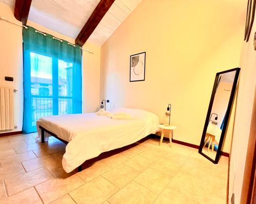a bedroom with a bed and a mirror and a window at La Casa di Totta in San Maurizio Canavese