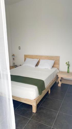 a bedroom with a large bed with white sheets at Heated pool, Casa Senda del Son-Cuautla in Los Limones