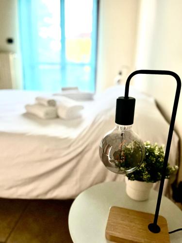 a lamp on a table next to a bed at La Casa di Totta in San Maurizio Canavese