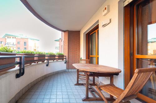 a balcony with a wooden table and two chairs at Martesana Terrace Flat with garage - Ospedale San Raffaele in Vimodrone